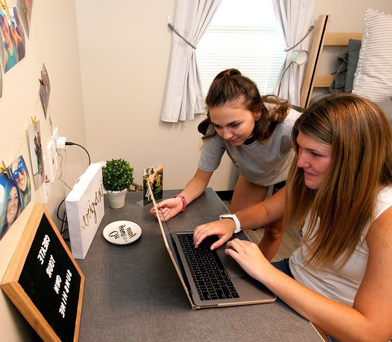 Students in dorm room on computer together